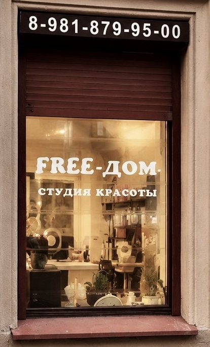 Окно студии FREE-ДОМ с надписью и телефоном на Захарьевской, 12